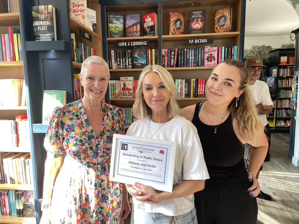 Three women smiling holding certificate