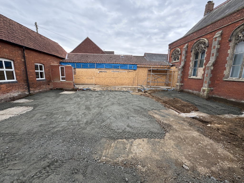A bare gravelly area between two buildings