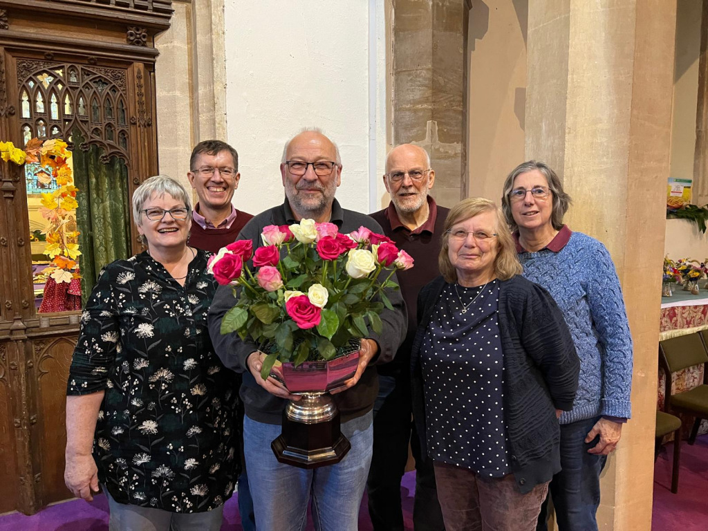 Group of people standing by a bouquet