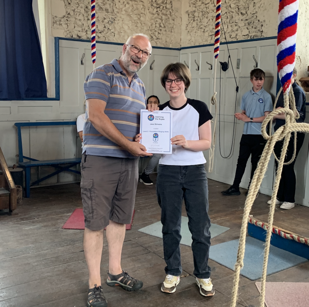 Two people holding an award certificate