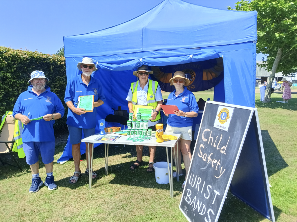 A group of people standing by a stall outside