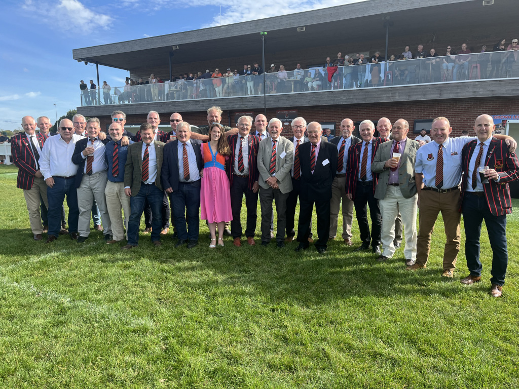 Group of people standing on a pitch in a line